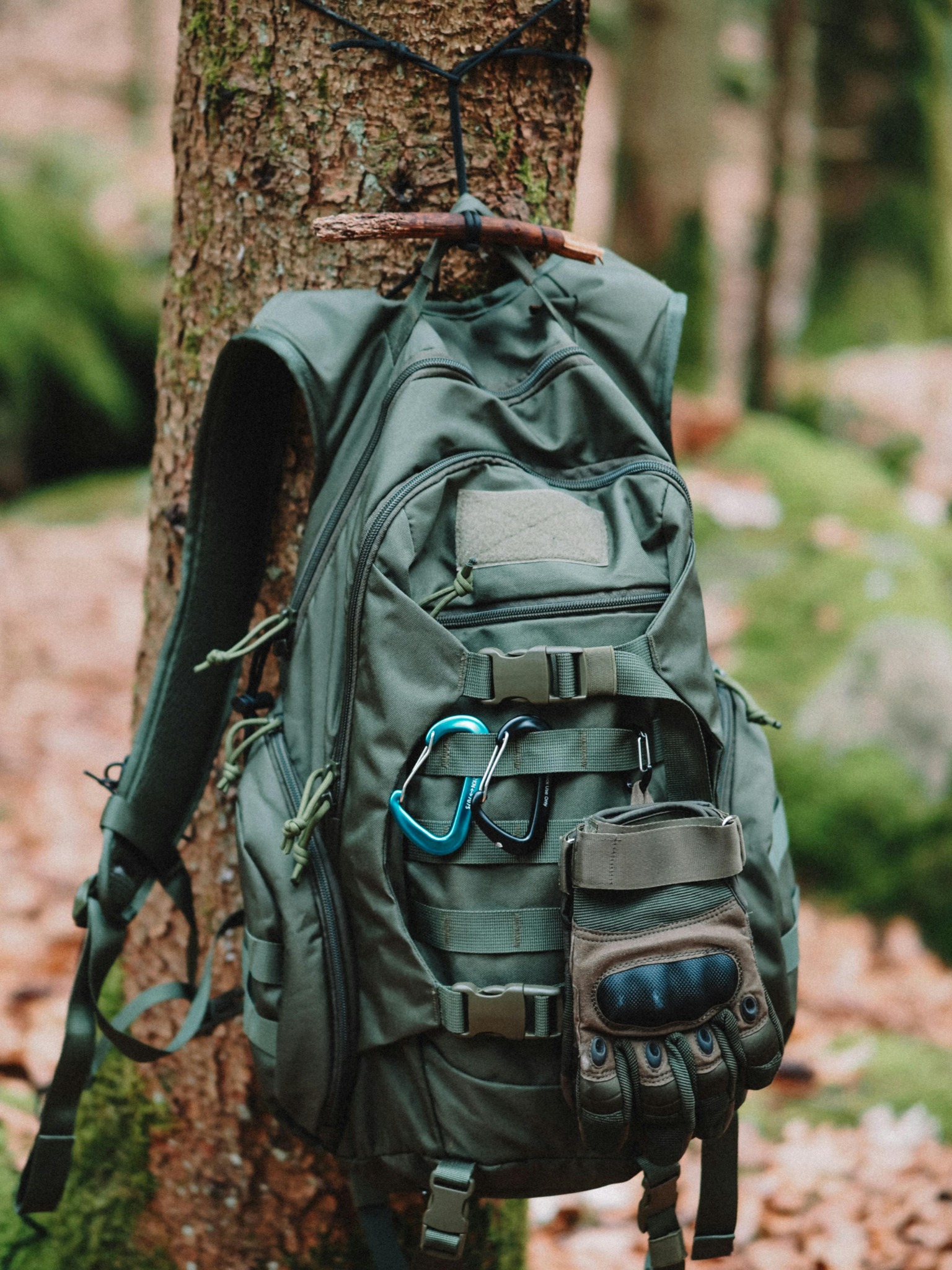 Outdoor backpack hanging from a tree with field accessories attached